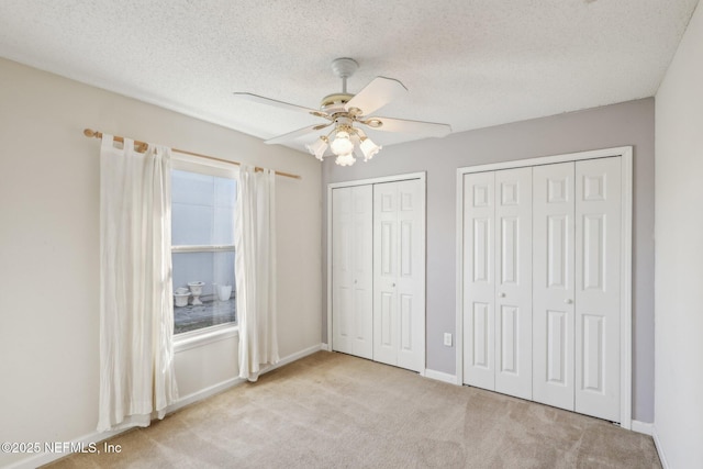 2721 Ridge Haven Dr, Green Cove Springs, FL 32043 - unfurnished bedroom featuring two closets, carpet, baseboards, a textured ceiling, and ceiling fan