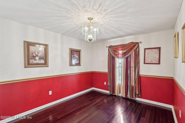 2721 Ridge Haven Dr, Green Cove Springs, FL 32043 - empty room with baseboards, a textured ceiling, wood finished floors, and an inviting chandelier