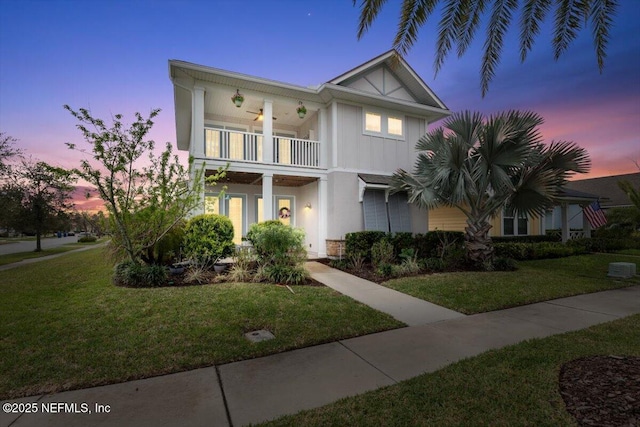 view of front facade featuring a front lawn, a balcony, and board and batten siding