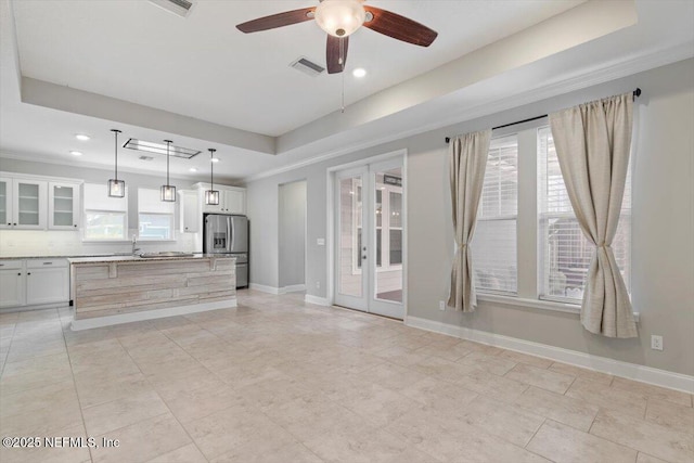 kitchen featuring visible vents, decorative light fixtures, french doors, stainless steel fridge, and a raised ceiling