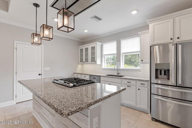 kitchen featuring visible vents, a sink, appliances with stainless steel finishes, crown molding, and decorative backsplash