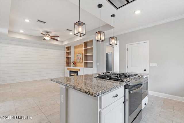 kitchen featuring built in features, a tray ceiling, stainless steel gas stove, and visible vents