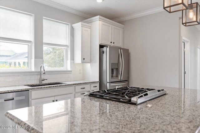 kitchen with a sink, white cabinets, appliances with stainless steel finishes, crown molding, and backsplash