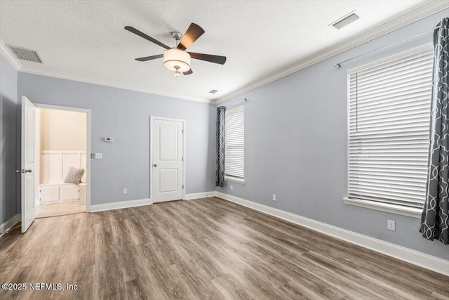 unfurnished bedroom with visible vents, a textured ceiling, and ornamental molding