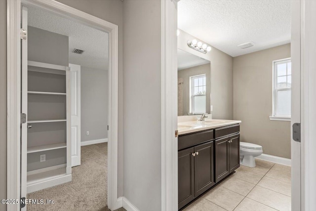 bathroom featuring vanity, toilet, visible vents, and a textured ceiling