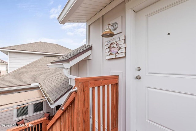 doorway to property featuring roof with shingles