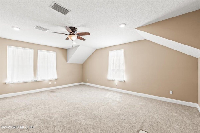 additional living space with visible vents, carpet flooring, and a textured ceiling