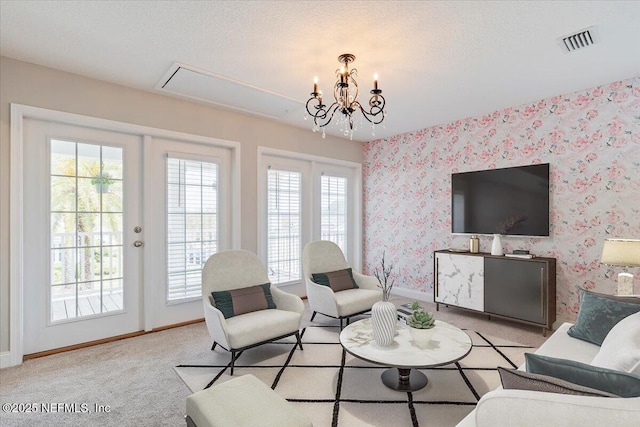 carpeted living room featuring visible vents, baseboards, wallpapered walls, an inviting chandelier, and french doors