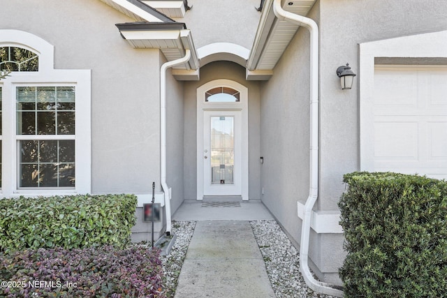 entrance to property featuring stucco siding