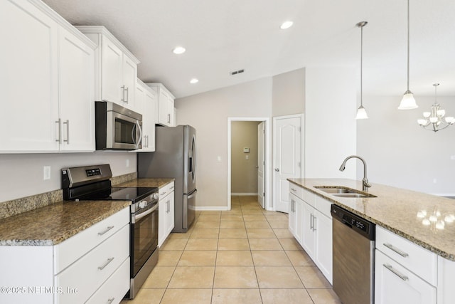 kitchen with a sink, appliances with stainless steel finishes, light tile patterned floors, and white cabinetry