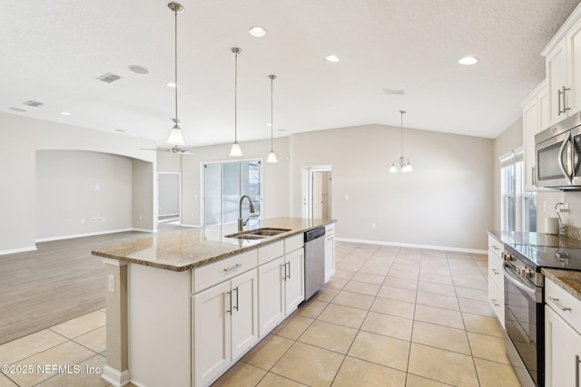 kitchen featuring visible vents, a sink, stainless steel appliances, light tile patterned floors, and lofted ceiling