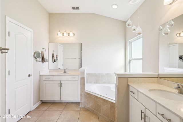 bathroom with vaulted ceiling, visible vents, two vanities, and a sink