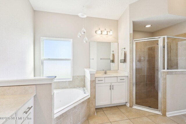 bathroom with vanity, a shower stall, a garden tub, and tile patterned floors