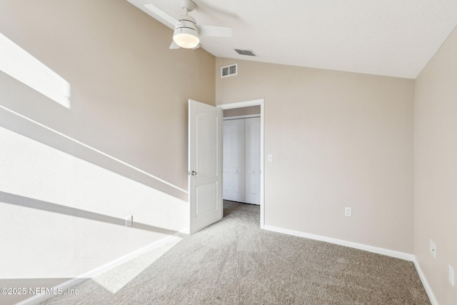 carpeted spare room featuring visible vents, ceiling fan, baseboards, and lofted ceiling