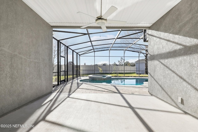 view of swimming pool featuring a pool with connected hot tub, a patio, fence, glass enclosure, and ceiling fan