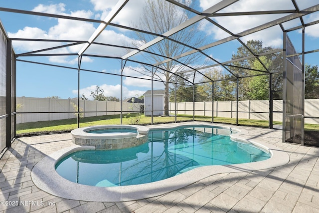 view of pool with a pool with connected hot tub, a lanai, a shed, a fenced backyard, and an outbuilding