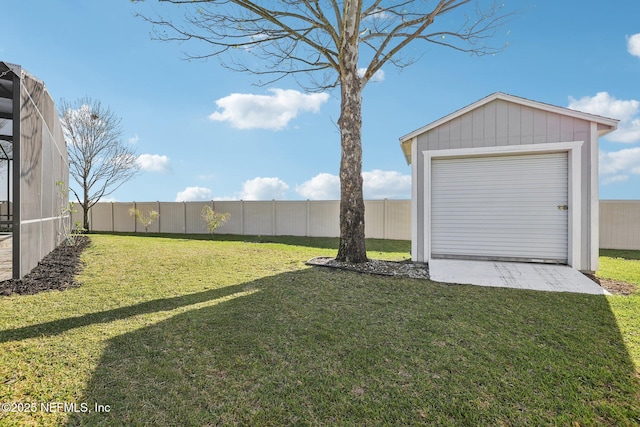 view of yard with an outbuilding, a lanai, a detached garage, and fence