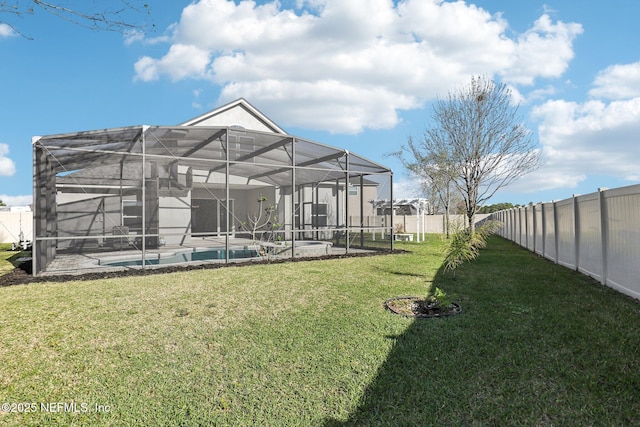 view of yard with a lanai, a fenced in pool, and a fenced backyard