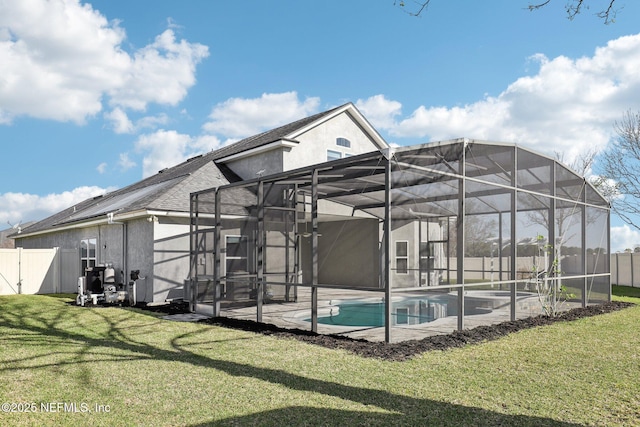 exterior space featuring glass enclosure, a fenced backyard, and a lawn