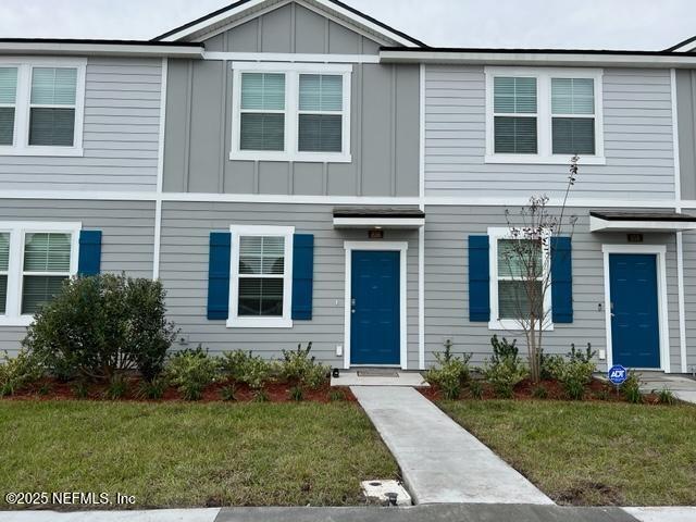 multi unit property with board and batten siding and a front lawn