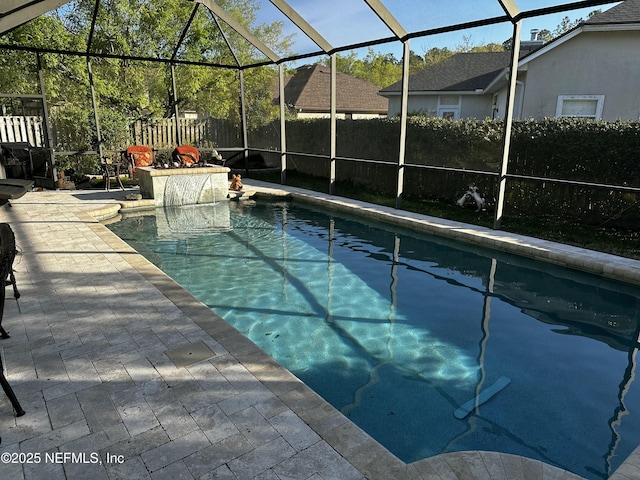 view of swimming pool featuring glass enclosure, fence, a fenced in pool, and a patio area