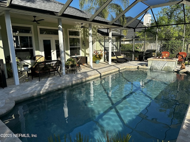 view of swimming pool featuring glass enclosure, a patio area, a fenced in pool, and ceiling fan