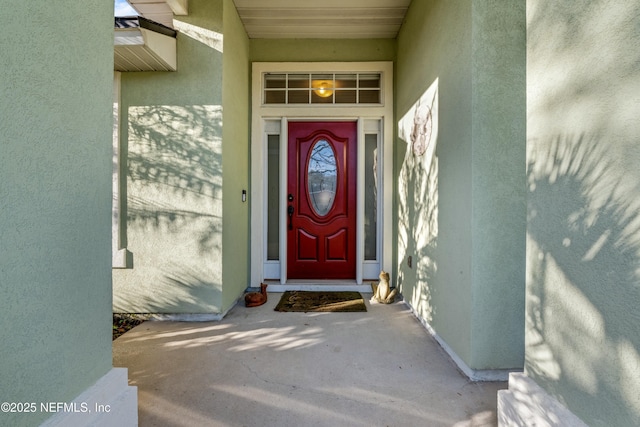 doorway to property featuring stucco siding