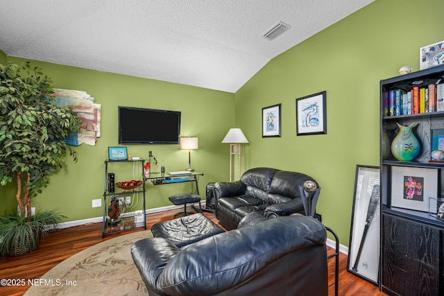 living room with wood finished floors, baseboards, visible vents, lofted ceiling, and a textured ceiling