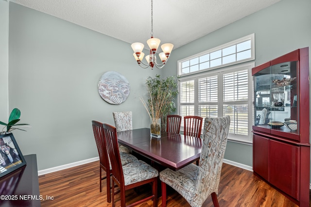 dining room featuring baseboards, wood finished floors, and a chandelier