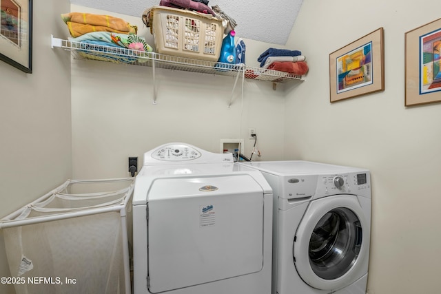 washroom with laundry area, washer and dryer, and a textured ceiling