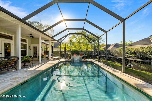 view of swimming pool featuring a ceiling fan, a fenced backyard, french doors, a lanai, and a patio area