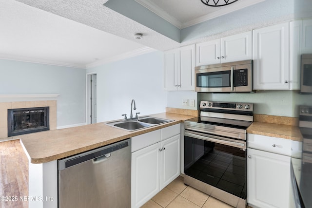 kitchen featuring a sink, a peninsula, crown molding, and stainless steel appliances