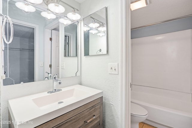 full bathroom featuring vanity, tile patterned floors, toilet, and a textured wall