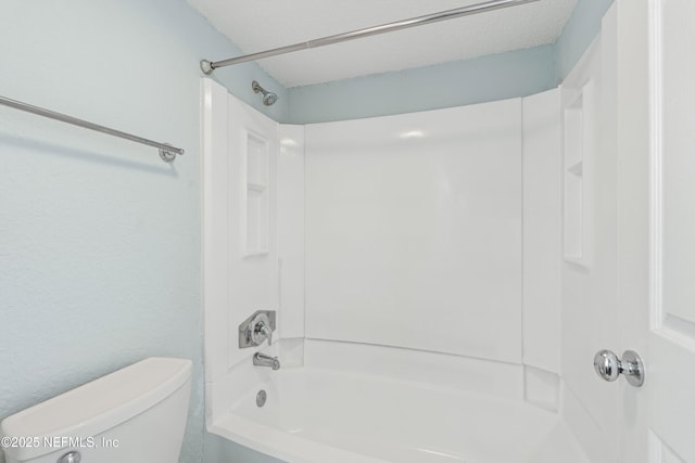 full bathroom featuring bathtub / shower combination, toilet, and a textured ceiling