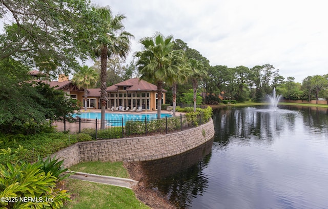 pool with fence and a water view