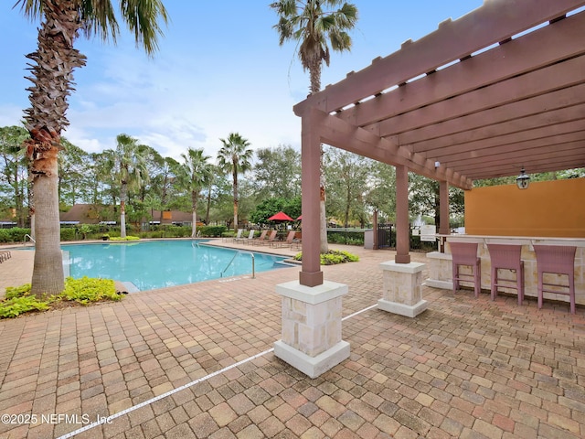 community pool featuring outdoor dry bar, a pergola, and a patio