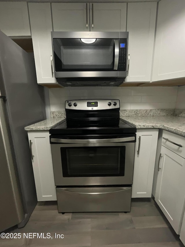 6655 Bell Tower Ct Unit 7, Jacksonville, FL 32217 - kitchen featuring white cabinets, dark wood-style flooring, stainless steel appliances, and tasteful backsplash