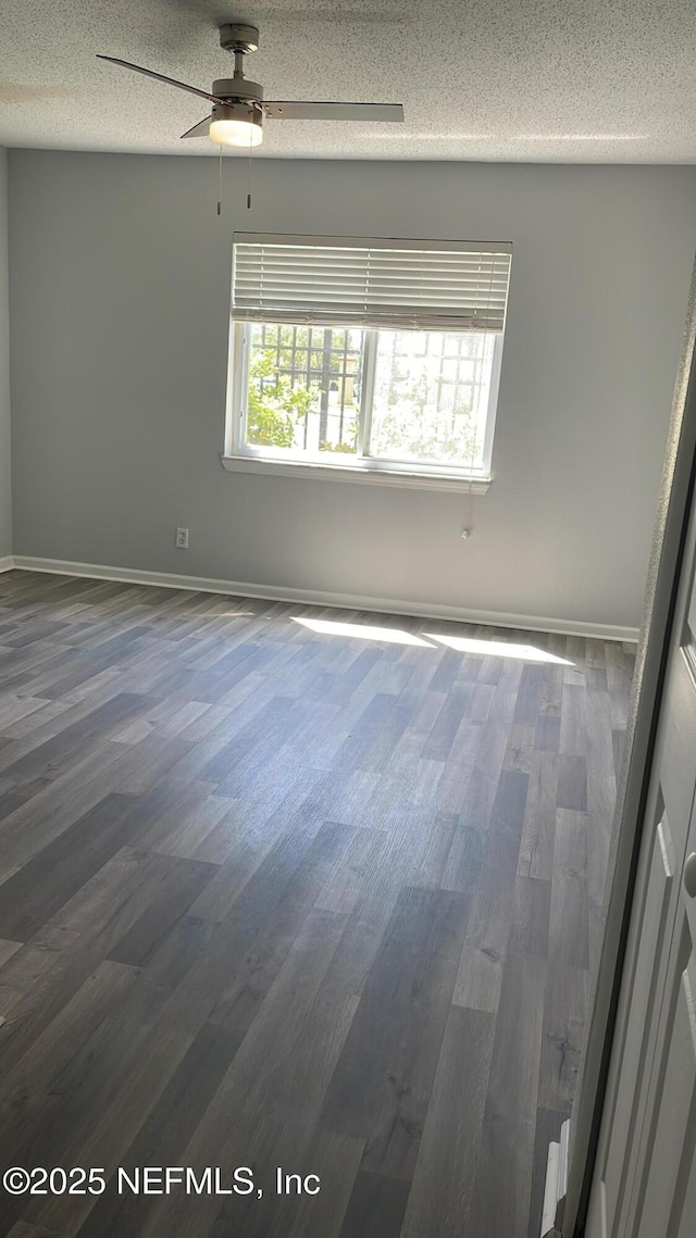 6655 Bell Tower Ct Unit 7, Jacksonville, FL 32217 - unfurnished room featuring dark wood finished floors, a textured ceiling, baseboards, and a ceiling fan