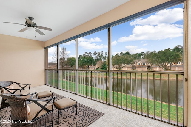 sunroom / solarium featuring ceiling fan and a water view