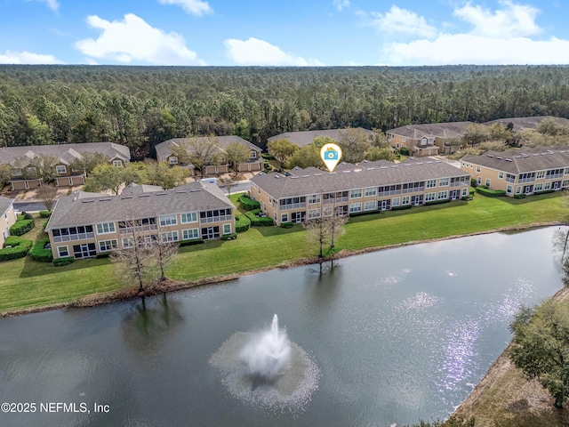 aerial view featuring a residential view, a wooded view, and a water view