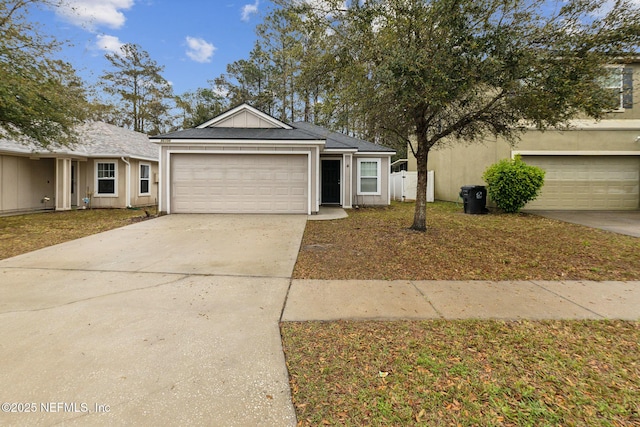 ranch-style house with a garage, driveway, and stucco siding