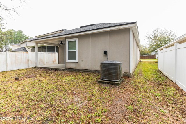 back of property featuring cooling unit, a fenced backyard, and a yard