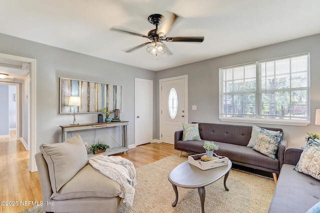 living room with wood finished floors, baseboards, and ceiling fan