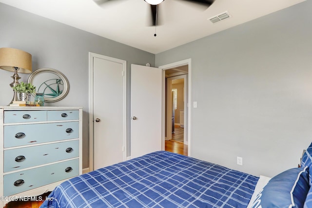 bedroom featuring visible vents, wood finished floors, and a ceiling fan