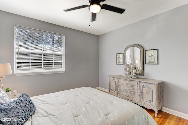 bedroom featuring baseboards, ceiling fan, and light wood finished floors