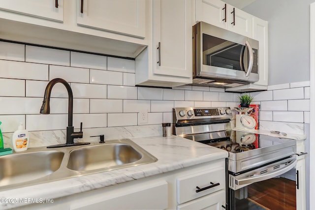 kitchen featuring a sink, white cabinets, tasteful backsplash, and stainless steel appliances