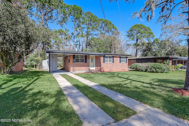 single story home featuring a carport, concrete driveway, a front yard, and brick siding