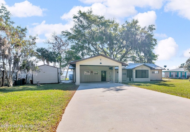 view of front of property with brick siding, an outdoor structure, concrete driveway, and a front lawn