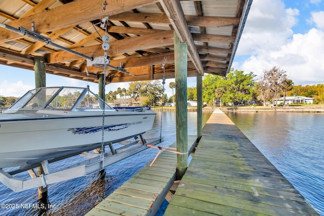 dock area with boat lift and a water view