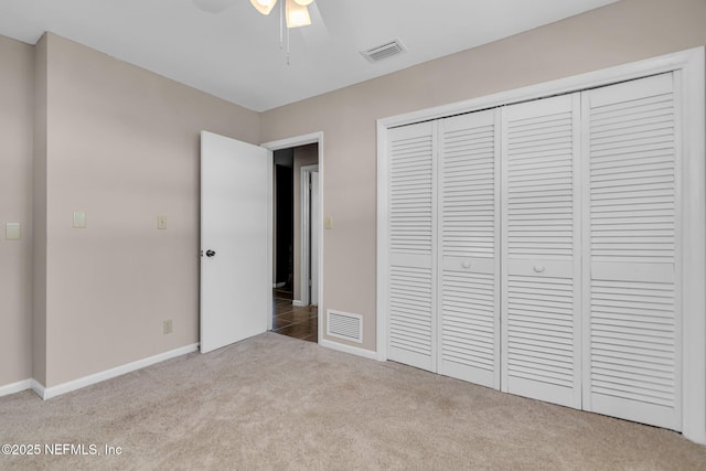 unfurnished bedroom with a closet, carpet flooring, baseboards, and visible vents